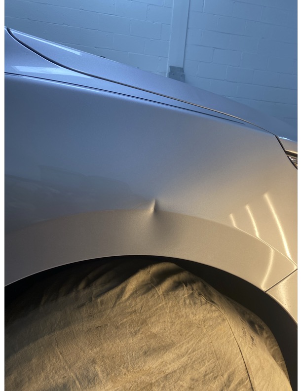 Fender dent before paintless dent repair