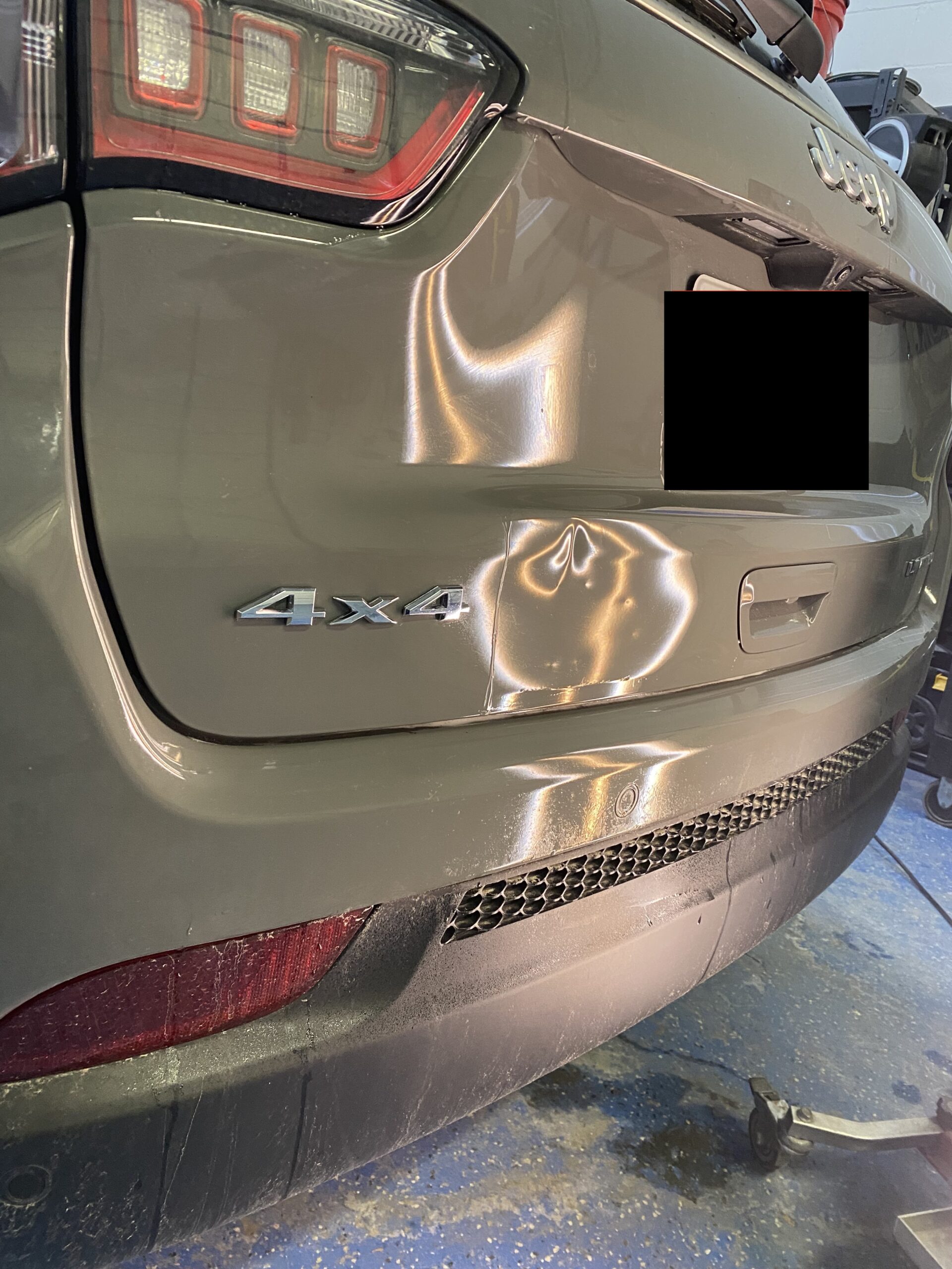 Large dent on a Jeep Compass liftgate before paintless dent repair
